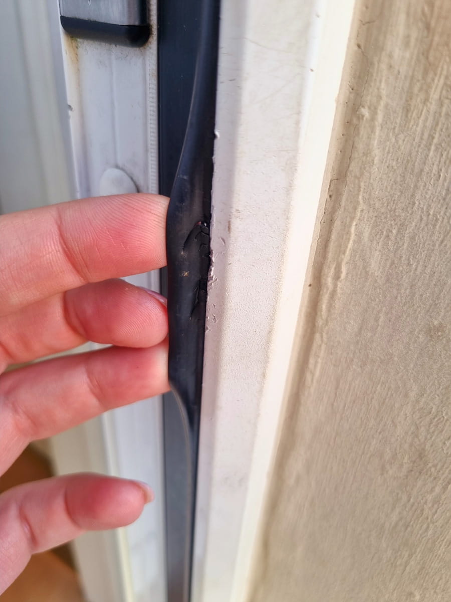 Close-up of a residential door showing gaps that allow cold air drafts and heat loss in Canadian homes.